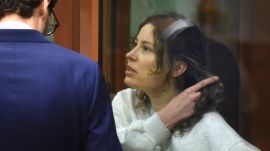 FILE - Ksenia Karelina speaks with her lawyer while standing in a glass cage in a court room in Yekaterinburg, Russia, Aug. 15, 2024. (AP Photo, File)