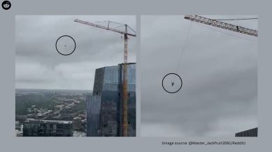 The footage captures a man casually swinging from a construction crane high above downtown Austin