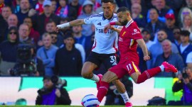 Liverpool's Mohamed Salah, right, kicks the ball ahead of Fulham's Antonee Robinson during the English Premier League soccer match between Fulham and Liverpool, at Craven Cottage, London, Sunday, April 6, 2025. (AP Photo)