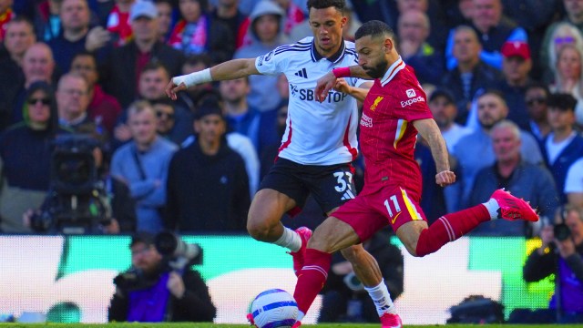 يركل محمد صلاح ليفربول ، إلى اليمين ، الكرة قبل أنونون روبنسون من فولهام خلال مباراة كرة القدم الإنجليزي الممتاز بين فولهام وليفربول ، في كرافن كوتاج ، لندن ، الأحد ، 6 أبريل 2025. (صورة AP)