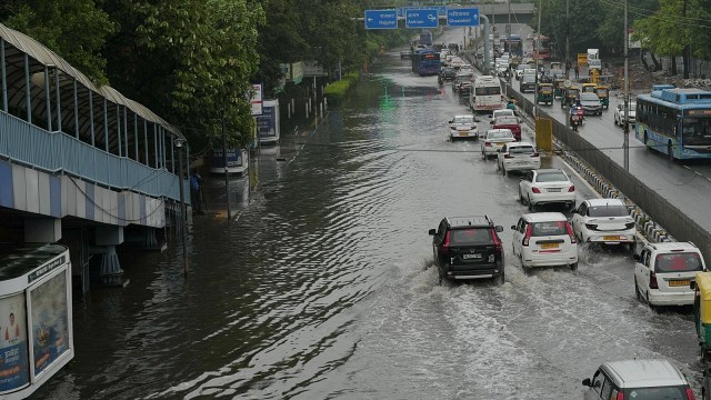 Vehicles wade through a waterlogged road following rains in New Delhi