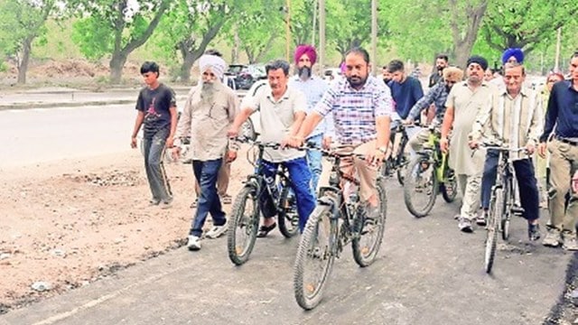 Mayor Amarjit Singh Jitti Sidhu rides a bicycle after inaugurating the first cycle track in Mohali
