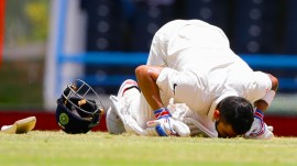 India's captain Virat Kohli kisses the field after scoring a double-century during day two of the first cricket Test match against West Indies at the Sir Vivian Richards Stadium in North Sound, Antigua, on July 22, 2016. (AP Photo)