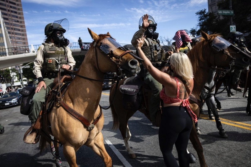 A woman gestures at mounted police moving in to disperse protesters in Los Angeles