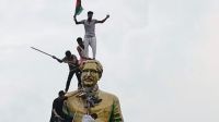 People climb the statue of Sheikh Mujibur Rahman at the Bijoy Sarani area, as they celebrate the resignation of the Prime Minister Sheikh Hasina in Dhaka, Bangladesh.