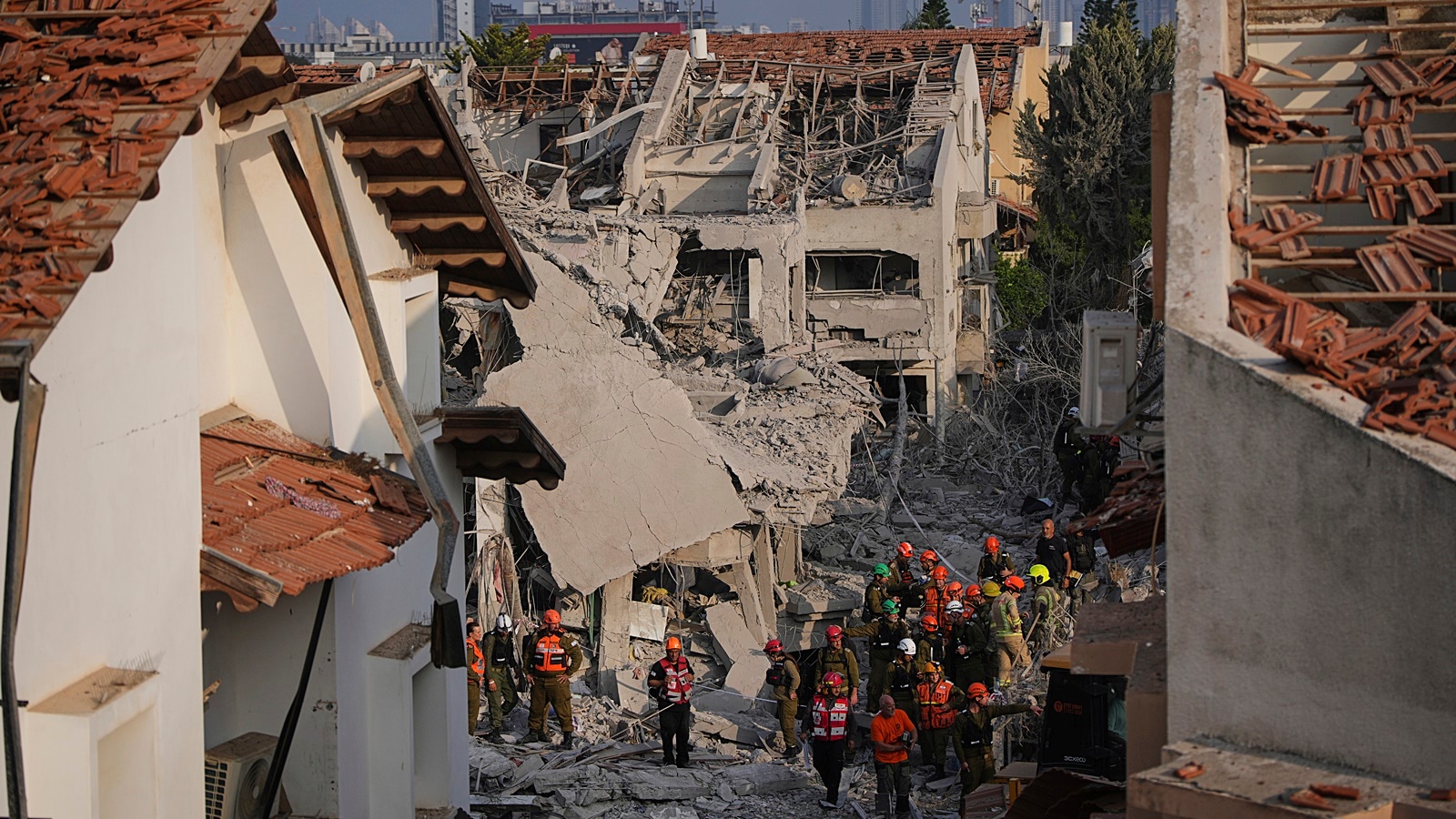 Israeli security forces inspect destroyed houses that were struck by a missile fired from Iran, in Rishon Lezion on Saturday