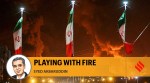 Iranian flags fly as fire and smoke from an Israeli attack on Sharan Oil depot rise, following Israeli strikes on Iran, in Tehran. (Reuters)