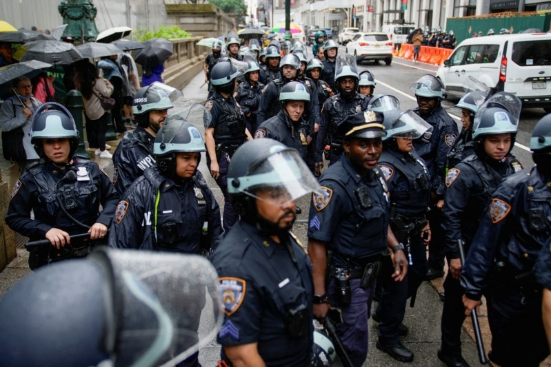 Police officers stand by as people start marching in New York