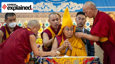 Attendant monks help Tibetan spiritual leader the Dalai Lama wear a ceremonial hat as he presides over an event celebrating his 90th birthday in Dharamshala on Monday.