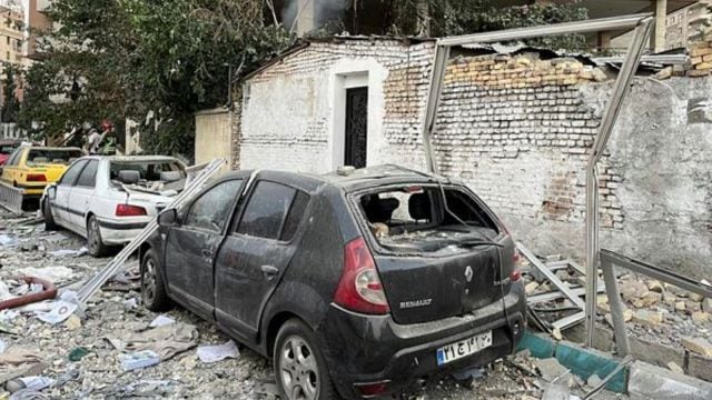 ebris from an apartment building is seen on top of parked cars after a strike in Tehran, Iran,