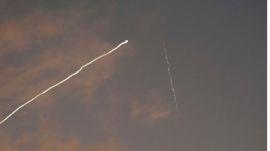 smoke trail from the Israeli Iron Dome air defense system streaks across the sky as it intercepts missiles launched during an Iranian attack