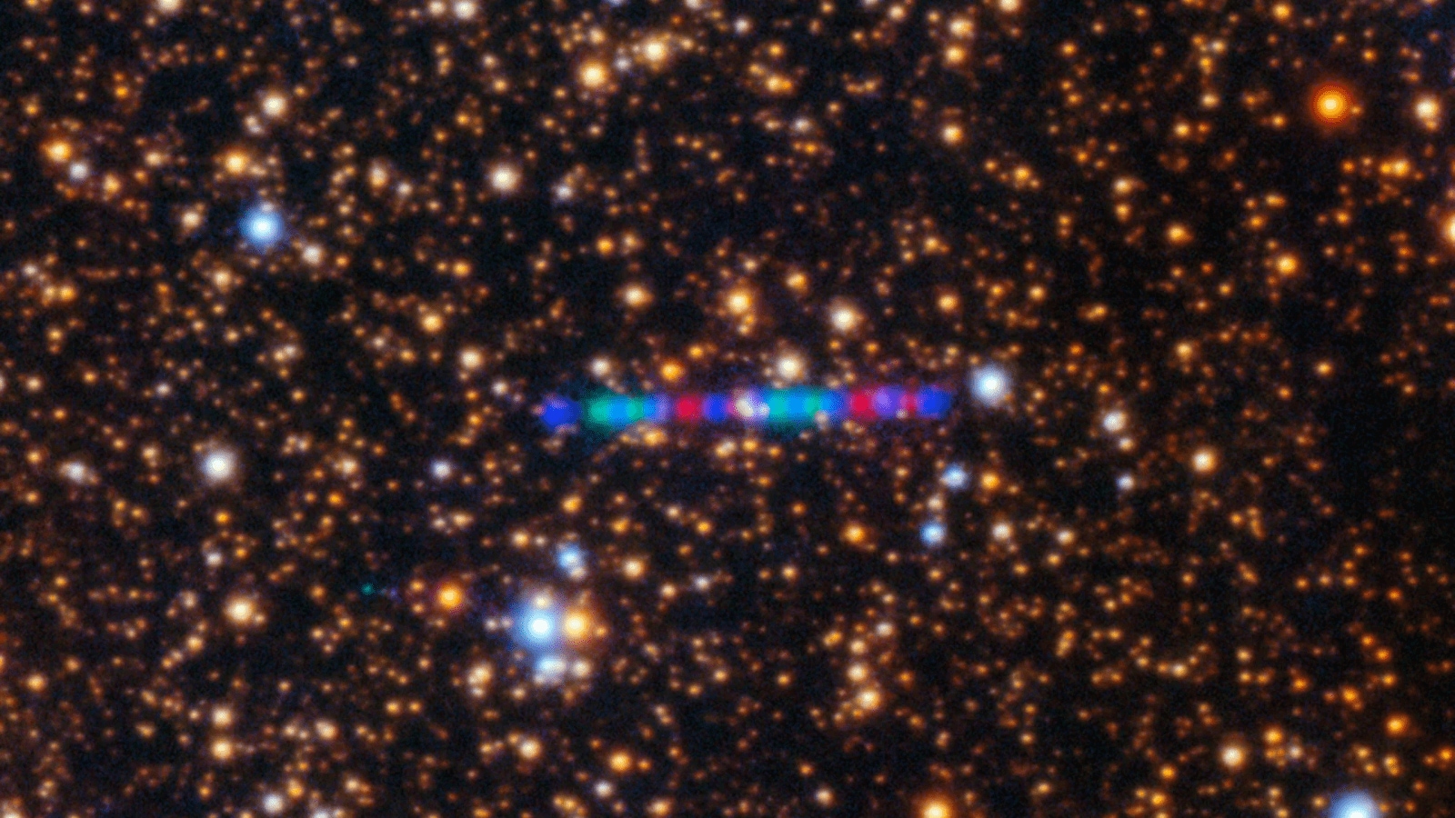 3I/ATLAS streaks across a dense star field in this image captured by the Gemini North telescope's Gemini Multi-Object Spectrograph (GMOS-N). The image is composed of exposures taken through three filters, shown here as red, green and blue. (Image Source: International Gemini Observatory)