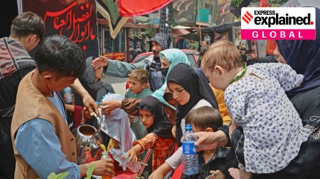 Afghan Shia worshippers receive juice from a stand before attending a sermon for Muharram in Kabul, Afghanistan, Sunday, July 6, 2025.
