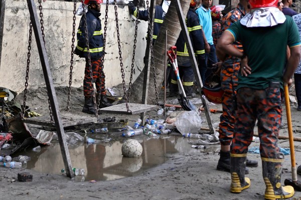 Firemen stand next to a swing as they work at the site. (AP Photo)