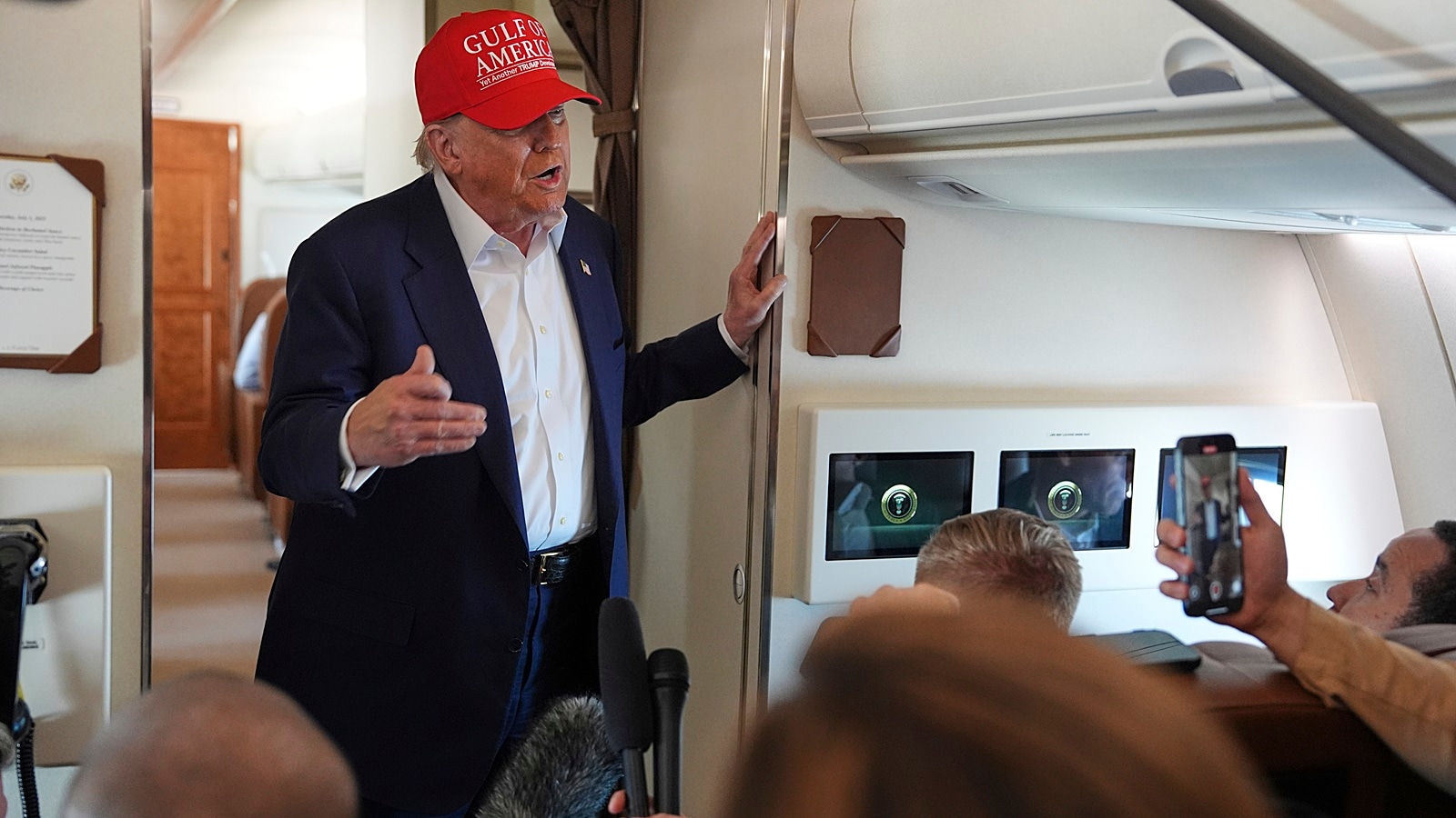 President Donald Trump talks with reporters on Air Force One