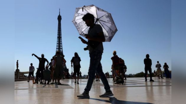 A tourist holding an umbrella to protect himself from the sun at Trocadero square, next to the Eiffel Tower, as the early summer heatwave hits Paris. The top floor of the Eiffel was shut to tourists while a red alert was issued for the city on Tuesday. More than a thousand schools were closed across France. (Reuters Photo)