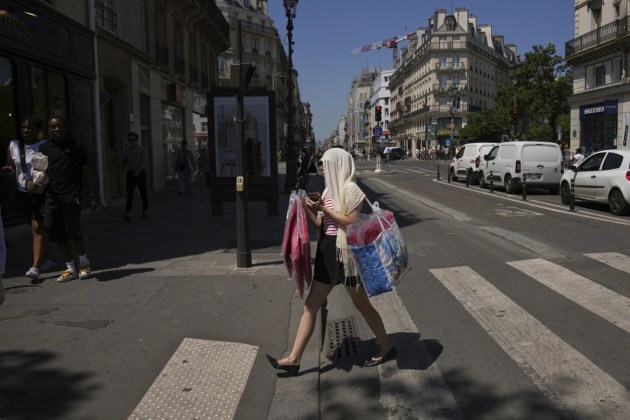 Two people have died in Italy as Europe continues to be engulfed in a blistering heatwave with several countries in the Mediterranian belt issuing record number of alerts. Heat warnings are in Italy, France, Germany, Portugal, the Netherlands. While Spain is on course to record its hottest June. In picture is a woman protecting her head during a heat wave in Paris. (AP Photo)