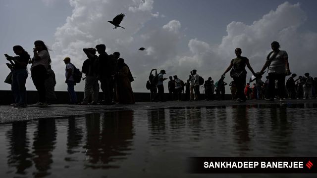 Tourists roam around at Marine Drive as IMD has sounded a yellow alert for the city, in Mumbai on 02 July 2025. (Express photo by Sankhadeep Banerjee)