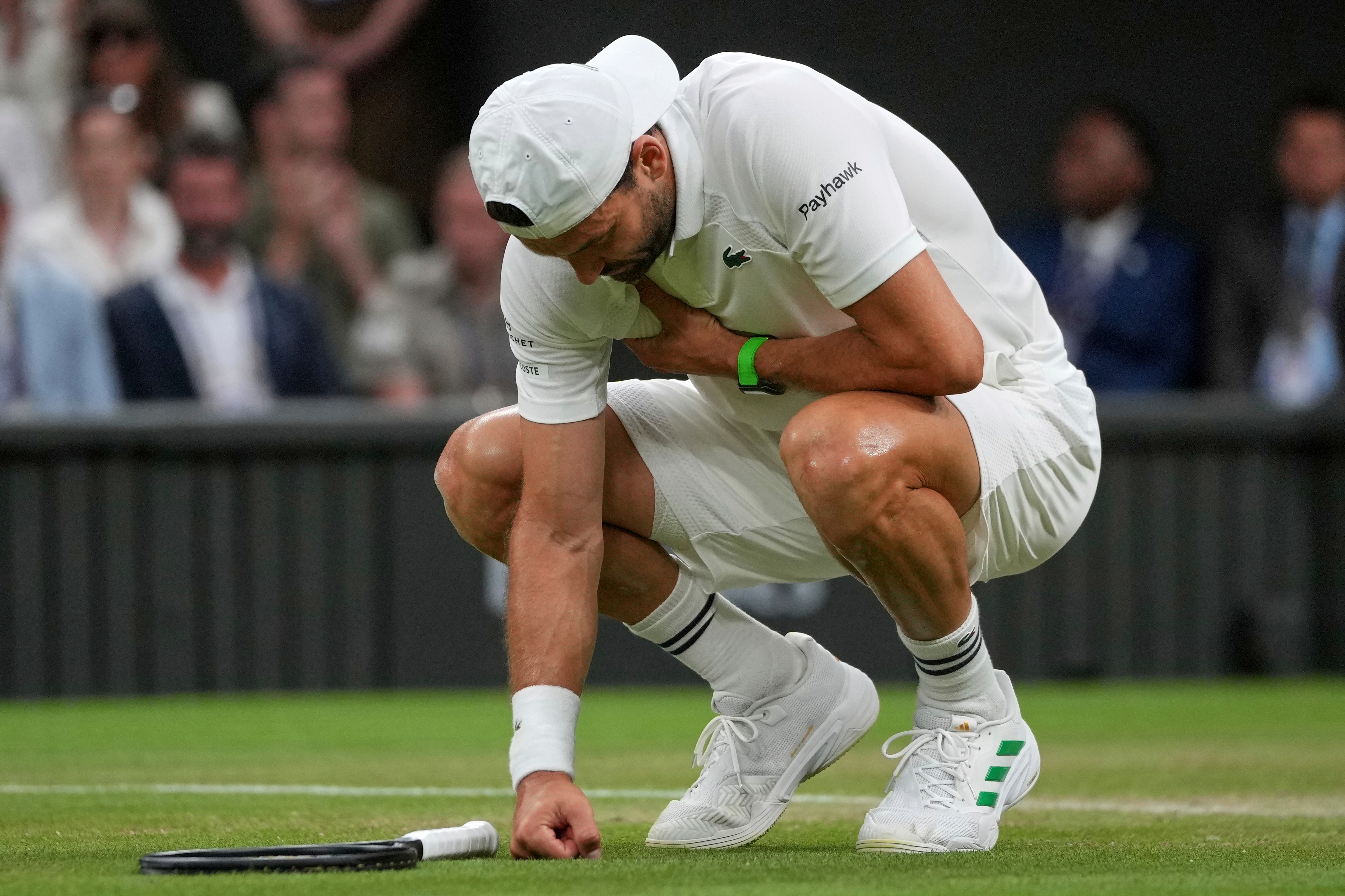 Bulgaria's Grigor Dimitrov clutches his chest with an injury which forced him to retire injured from a fourth round men's singles match against Italy's Jannik Sinner at the Wimbledon Tennis Championships in London, Monday, July 7, 2025. (AP Photo)