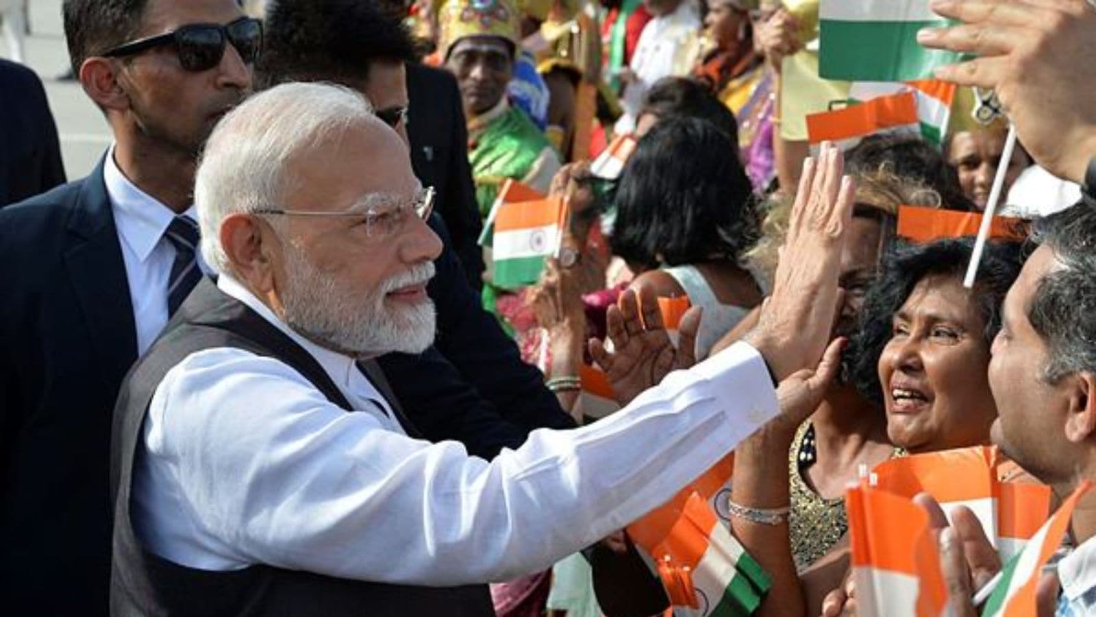 Prime Minister Narendra Modi greets people upon arriving at Piarco International Airport in Piarco, Trinidad and Tobago