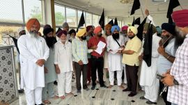 Villagers of Aligarh in Ludhiana district showing black flags to the government officials who came to organise landpooling awareness campaign Wednesday.