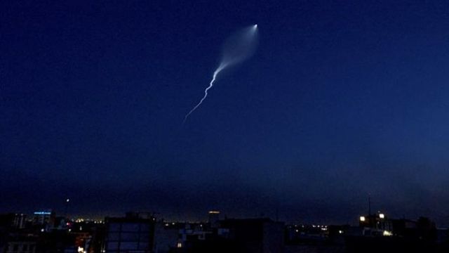 The trail of a missile launched by Iran is visible across the sky in Tehran, Iran, Wednesday, June 18, 2025. Most of the city's lights were off, some areas had been evacuated, and others remained dark intentionally.