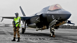 A CISF officer standing guard next to a British Royal Navy jet that made emergency landing in Kerala (ANI)