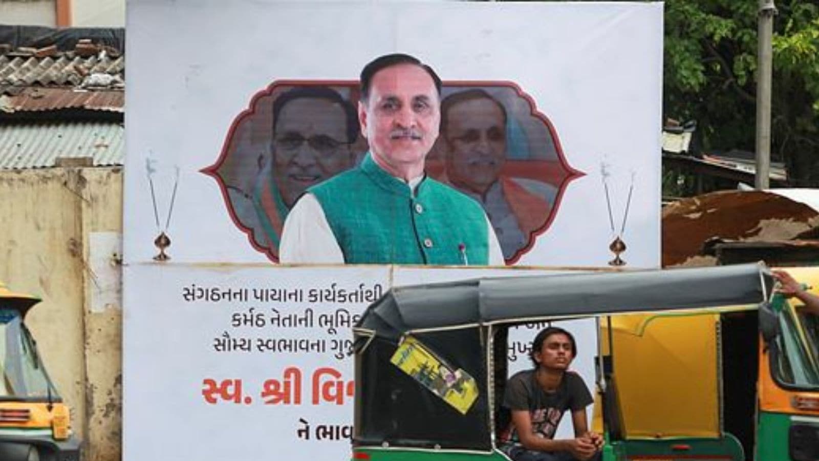 A poster put near Civil Hospital in Ahmedabad on Monday to give tribute to Late Former CM Vijay Rupani by Bhartiya Janta Party. (Express photo by Bhupendra Rana)