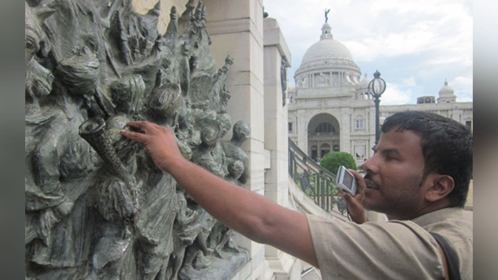A visually challenged photographer connects with their subject by touch, capturing its texture and form before shooting at Kolkata’s Victoria Memorial during 'Blind with Camera' workshop. (Express Photo)