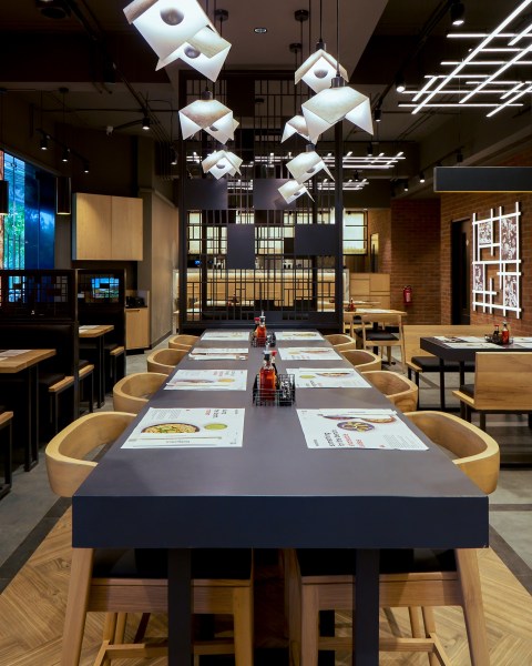 The Mumbai outpost, spread across 4,000 sqft, offers a space that’s minimal yet warm, reflecting its signature design with concrete and wood textures, bench seating, and origami-style hanging lamps.