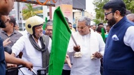 Karnataka Deputy CM DK Shivakumar riding his restored motorcycle on a new flyover.