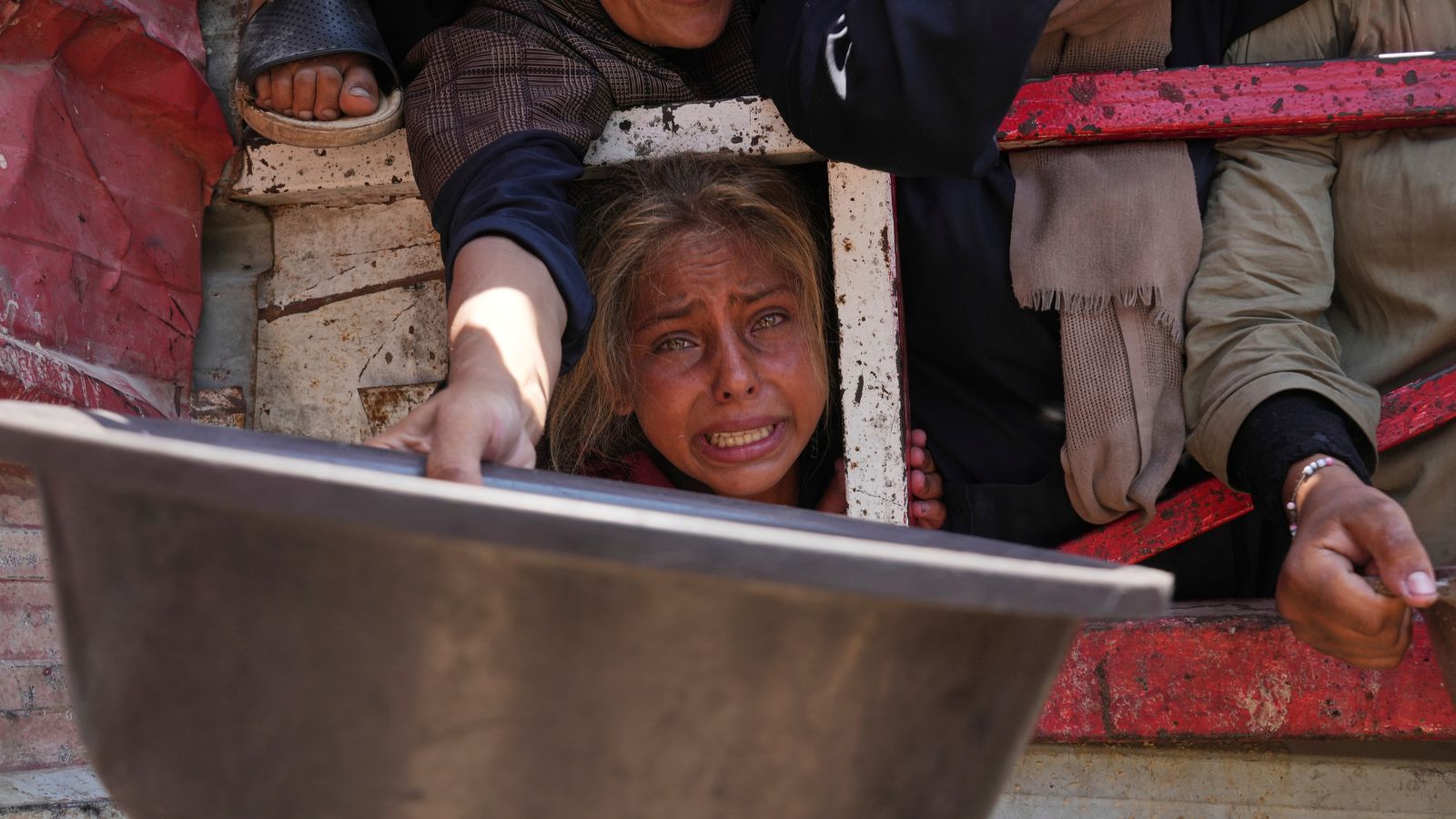 Palestinians struggle to receive donated food at a community kitchen in Gaza City, northern Gaza Strip, July 26, 2025. (AP Photo/Abdel Kareem Hana)