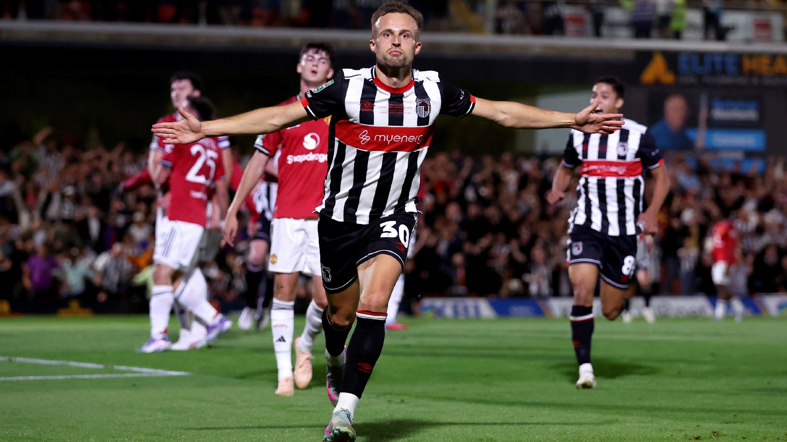 Grimsby Town's Charles Vernam celebrates scoring their side's first goal of the game during an English League Cup second round soccer match against Manchester United. (PA via AP)
