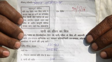 A villager show his water bill in Gurgaon