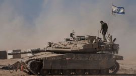 An Israeli soldier stands on the top of a tank parked on an area near the Israeli-Gaza border, as seen from southern Israel, Wednesday, Aug. 20, 2025. (AP Photo/Maya Levin)