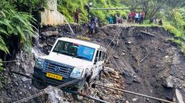 A vehicle being lifted from the debris of a damaged road after heavy rainfall, in Kullu district, Himachal Pradesh