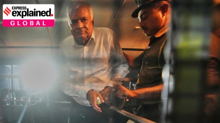 Former Sri Lankan President Ranil Wickremesinghe is escorted by a prison officer inside a bus taking him from court to a prison in Colombo, Sri Lanka, Friday, Aug. 22, 2025.
