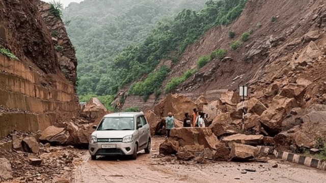 People move past debris and boulders after a landslide blocked a road at Samletu, in Bilaspur district, Himachal Pradesh