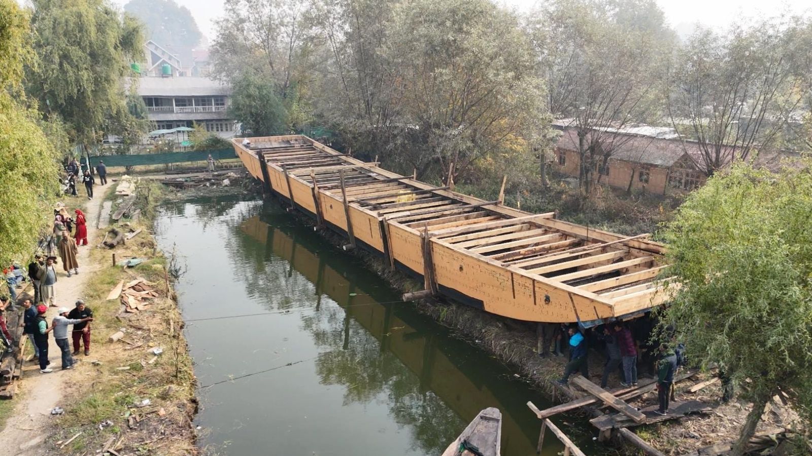 The completed hull of a houseboat being pushed into the water. Photo credit: Sayali Athale / Anto Gloren
