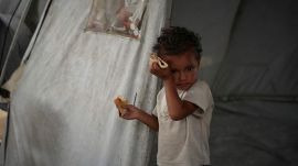 Three-year-old Jourieh Razayneh wipes sweat from her forehead in the summer heat at her family's tent in Gaza City, Tuesday, August 12, 2025. (AP Photo/Jehad Alshrafi)
