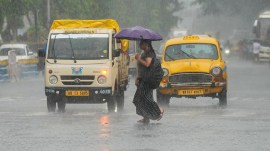 Commuters make their way amid rainfall, in Kolkata