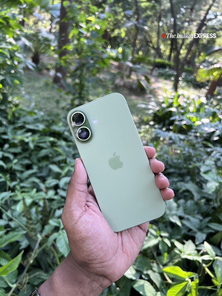 Sage-green iPhone 17 showcasing its clean, minimalist design and sleek dual-camera layout against a lush green backdrop. (Image: Bijin Jose/The Indian Express)