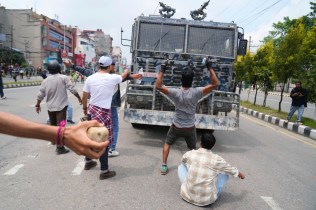 Protesters shout slogans in front of an armored vehicle outside the Parliament building in Kathmandu, Nepal, Monday, Sept. 8, 2025. (AP Photo/Niranjan Shrestha)