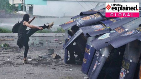 An anti-corruption protester kicks the shield of a policeman during clashes in Manila, Philippines on Sunday, Sept. 21, 2025.