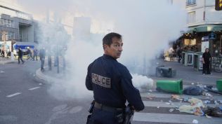 France A police officer stands next to bins placed on a street to block it during the "Bloquons Tout" (Block Everything) protest movement in Paris, Wednesday, Sept. 10, 2025. (AP Photo/Thibault Camus)