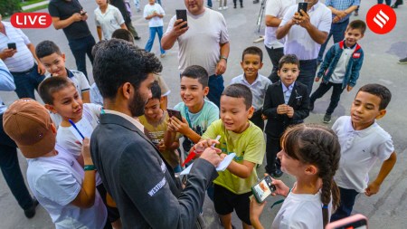 FIDE Grand Swiss 2025 Round 4: World champion Gukesh Dommaraju greets young chess fans from Uzbekistan on a day he played against Arjun Erigaisi in the fourth round at Samarkand. (PHOTO: FIDE via Michal Walusza)