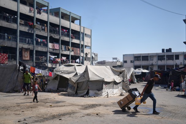 A man carries food at UN school used as a shelter for displaced Palestinians in Khan Younis, Tuesday, Sept 30, 2025. (AP Photo/Jehad Alshrafi)