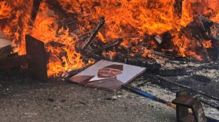 Protesters burn a photograph of Nepal's Prime Minister Khadga Prasad Oli at the Singha Durbar, the seat of Nepal's government's various ministries and offices during a protest against social media ban and corruption in Kathmandu, Nepal, Tuesday, Sept. 9, 2025. (AP Photo/Niranjan Shrestha)