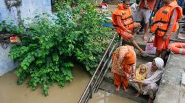 Family members of a toddler perform rituals at their partially submerged house as the water level of the Yamuna river continues to rise, in New Delhi, Wednesday, Sept. 3, 2025.