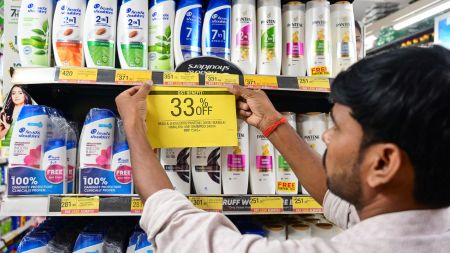 A man puts a 33% off poster on shampoo bottles, at a shop, in Prayagraj, Monday, Sept. 22, 2025. The new GST rates came into effect. (PTI Photo)